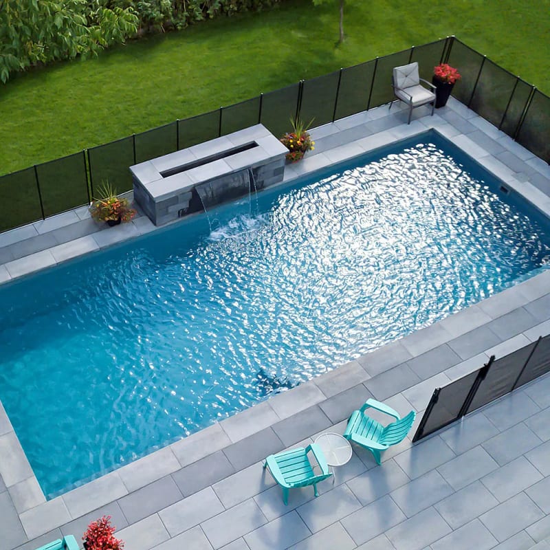 Aerial view of rectangle fiberglass pool with water feature and patio furniture