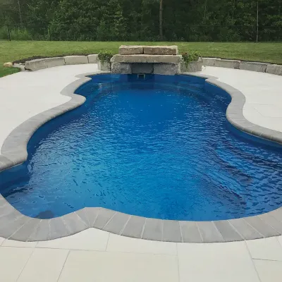 Freeform fiberglass pool with clear blue water